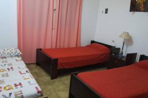 Un dormitorio con 2 camas con sábanas rojas y una falda en Entre Montañas en La Rioja