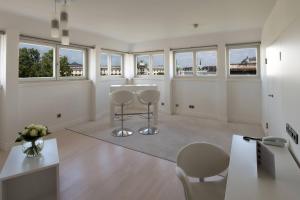 a white room with chairs and a table and windows at Le Méridien Vienna in Vienna