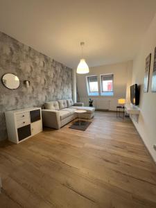 a living room with a couch and a table at Apartamenty Przy Rynku Trzebnica in Trzebnica