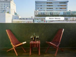 dos sillas y una mesa con botellas de vino y copas en Loft Roma Norte en Ciudad de México