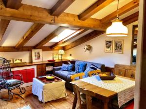 a living room with a blue couch and a table at Mansardina Mery Cortina in Cojana