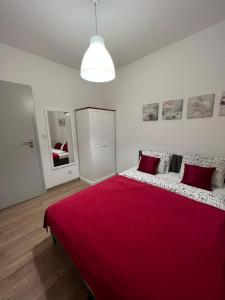 a bedroom with a large bed with a red blanket at Apartamenty Przy Rynku Trzebnica in Trzebnica