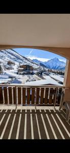 a view of a snowy mountain from a balcony at Au pied des pistes avec panorama sur les montagnes in Les Deux Alpes