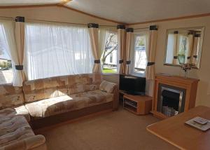 uma sala de estar com um sofá e uma lareira em Rosneath Castle Park em Rhu