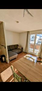 a living room with a couch and a table at Au pied des pistes avec panorama sur les montagnes in Les Deux Alpes