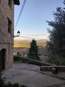 un bâtiment en pierre avec un éclairage de rue sur son côté dans l'établissement Can Marisa, à La Fresneda