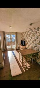 a living room with a wooden table and a flower wall at Au pied des pistes avec panorama sur les montagnes in Les Deux Alpes