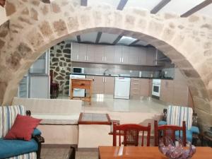 a kitchen with a stone archway in a living room at Can Marisa in La Fresneda