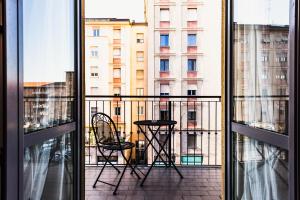 Habitación con vistas a un balcón con mesa y sillas. en Gegix's Rooms Milano en Milán