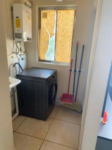 uma lavandaria com uma máquina de lavar roupa e uma janela em Departamento Full Amoblado en Talca em Talca