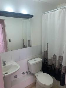 a white bathroom with a toilet and a sink at Departamento Full Amoblado en Talca in Talca