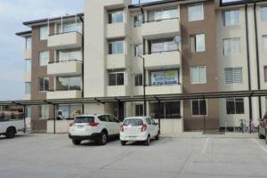 two cars parked in a parking lot in front of a building at Departamento Full Amoblado en Talca in Talca