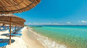 a beach with chairs and umbrellas and the ocean at ALEXANDER APARTMENT'S in Kallithea Halkidikis