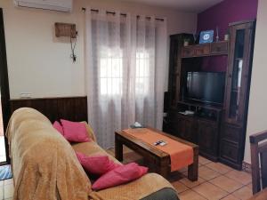 a living room with a couch and a tv at Entrecuevas in Setenil