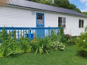 a house with a blue fence and some plants at Big Axe Bed & Breakfast in Otis