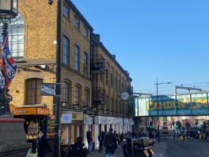 un grupo de personas caminando por una calle de la ciudad en Luxury Apartment Camden Town en Londres