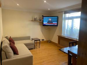sala de estar con sofá y TV en la pared en Luxury Apartment Camden Town en Londres