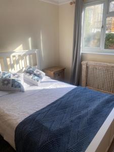 1 dormitorio con 1 cama con edredón azul y ventana en Luxury Apartment Camden Town en Londres