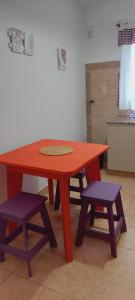 una mesa de madera y 2 taburetes en la cocina en Dpto. 2 dormitorios totalmente equipado en Salta