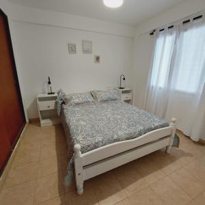 Habitación blanca con cama y ventana en Dpto. 2 dormitorios totalmente equipado en Salta