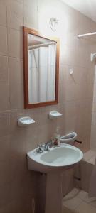 y baño con lavabo, espejo y aseo. en Dpto. 2 dormitorios totalmente equipado en Salta