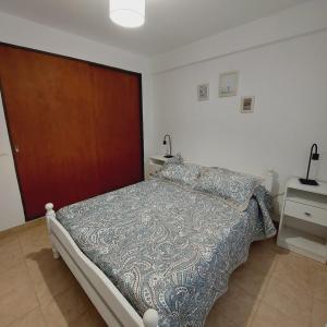 1 dormitorio con 1 cama y puerta de madera en Dpto. 2 dormitorios totalmente equipado en Salta
