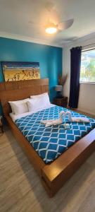 1 dormitorio con 1 cama grande y edredón azul en Family Suite in a Unique Resort - next to splash zone for kids and restaurant, en Gold Coast