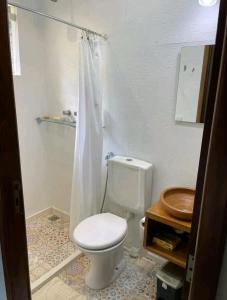 a bathroom with a toilet with a shower curtain at Sítio Vale Das Flores in Maricá