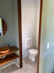 a bathroom with a toilet and a mirror at Sítio Vale Das Flores in Maricá
