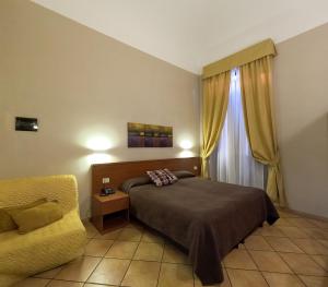 1 dormitorio con 1 cama, 1 silla y 1 ventana en Hotel Cervia en Roma