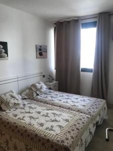 1 dormitorio con cama y ventana en Apartamento “El Callao”, en Puerto del Rosario
