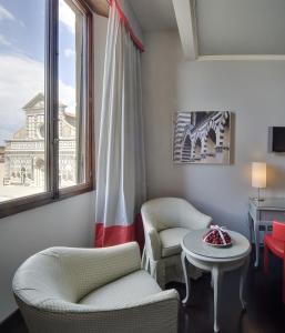 Zimmer mit 2 Stühlen, einem Tisch und einem Fenster in der Unterkunft Hotel Rosso23 - WTB Hotels in Florenz
