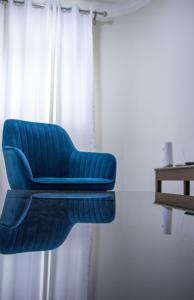 a blue chair sitting in front of a window at Chic Guest House & Solar system free from load shedding in Germiston