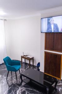 a living room with a tv and a chair and a table at Chic Guest House & Solar system free from load shedding in Germiston