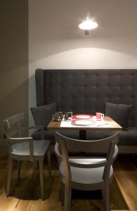 einen Tisch und Stühle mit einem Tisch und einem Sofa in der Unterkunft Hotel Rosso23 - WTB Hotels in Florenz