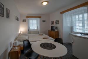 een slaapkamer met een bed en een tafel en stoelen bij Apartmá u Baštů in Česká Kamenice