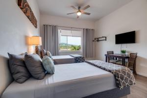 a bedroom with a king sized bed with a flat screen tv at Uncle Tonys Hale in Wailuku