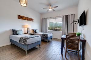 a bedroom with a bed and a desk and a chair at Uncle Tonys Hale in Wailuku