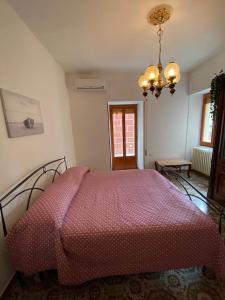 Schlafzimmer mit einem Bett mit einer roten Bettdecke in der Unterkunft 1931 Apartments - Borgo Antico - Gargano in Ischitella
