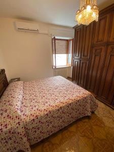 Schlafzimmer mit einem Bett und einem Kronleuchter in der Unterkunft 1931 Apartments - Borgo Antico - Gargano in Ischitella