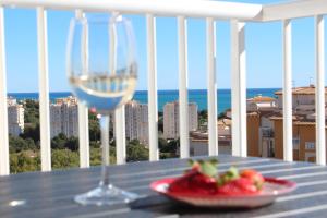 een glas wijn en een fruitschaal op een tafel bij New apartment with sea view of Andrew and Natallia in Campoamor