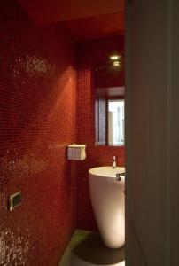 uma casa de banho com um lavatório branco e um espelho. em Hotel Rosso23 - WTB Hotels em Florença