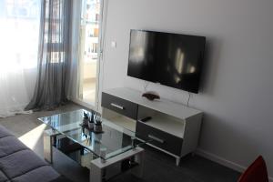 een woonkamer met een tv en een glazen salontafel bij New apartment with sea view of Andrew and Natallia in Campoamor