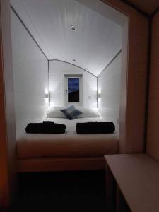 a bedroom with a large white bed in a mirror at Loch Shiel Luxury Pod in Acharacle