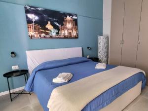 una camera con un letto con una parete blu di Il vicolo home a Catania
