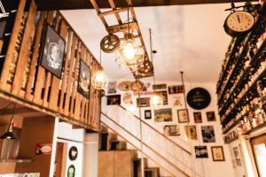 un pasillo con relojes y cuadros en las paredes en El Refugio de la cerveza - La Morada de la Cerveza, en Villena