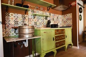 una cocina con armarios verdes y azulejos en la pared en El Refugio de la cerveza - La Morada de la Cerveza, en Villena