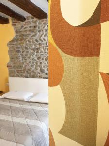 a bedroom with a bed and a stone wall at B&B Home Sweet Home in Bergamo