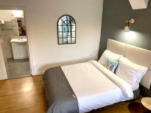 a bedroom with a white bed and a bathroom at Brasseurs Du Pont - Microbrasserie avec chambres in Siorac-en-Périgord