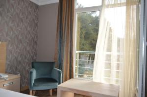 a room with a chair and a window at hotel kale palas in Gokceada Town